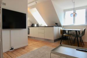 オーフスにあるCozy 1-bedroom apartment in Øgadekvarteret in central Aarhus - 43のテレビとテーブルのあるリビングルーム +3枚の写真
