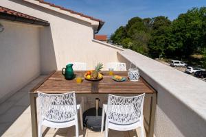 uma mesa numa varanda com uma taça de fruta em Ferienwohnung Residence Mala 1 mit Pool em Funtana