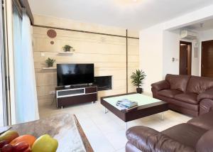een woonkamer met een bank en een tv bij Coral Azure in Paphos