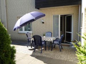 a table with chairs and an umbrella on a patio at Ferienwohnung Kerstin in Soltau
