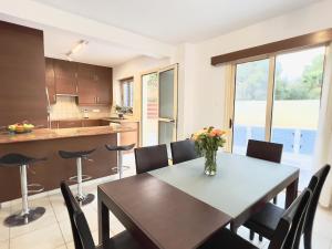 Paphos的住宿－Coral Azure，厨房以及带桌椅的用餐室。