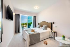 Habitación de hotel con cama y balcón en Hotel Vibra Palma Cactus, en Playa de Palma