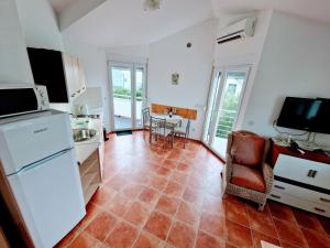 una cucina con frigorifero e tavolo con sedia di Apartmani Villa Medići a Vrsi (Verchè)