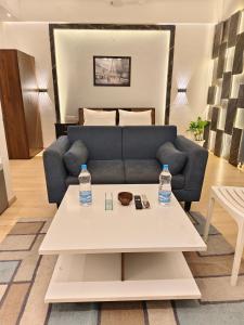 ein Wohnzimmer mit einem Sofa und 2 Wasserflaschen auf dem Tisch in der Unterkunft 4 Season hotel in Lucknow