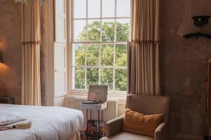 una camera con letto, finestra e sedia di No 15 by GuestHouse, Bath a Bath