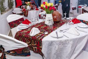 a table with white table cloths and flowers on it at Muthu Warwick Mount Kenya Hotel, Nanyuki in Nanyuki