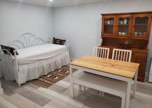 Un dormitorio con una cama y una mesa y sillas. en Grace Haven, en Oakville