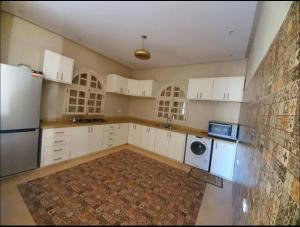 a kitchen with white cabinets and a washer and dryer at Villa Ourika ,Roche Rouge in Ourika
