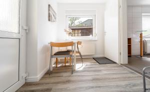 a dining room with a table and chair and a window at Villa Helga- Fewo Morgensonne mit Terrasse, Kamin und 2 Schlafzimmer in Zinnowitz +17 photos