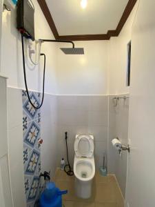 a small bathroom with a toilet and a shower at SHELVES SIARGAO in General Luna