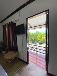 a room with a door open to a balcony at SHELVES SIARGAO in General Luna