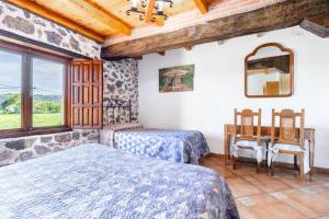 1 Schlafzimmer mit 2 Betten, einem Tisch und einem Fenster in der Unterkunft Casa Transmiera in Solórzano