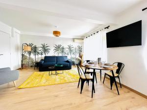 - un salon avec une table et un canapé bleu dans l'établissement Le CozyCroisette - Centre Cannes - 6 personnes, à Cannes