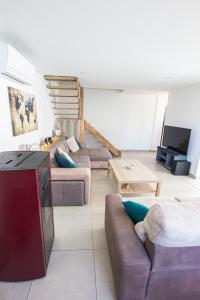 a living room with two couches and a tv at La Maison du Lac - Puimoisson in Puimoisson