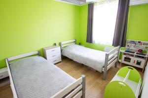 a small bedroom with two beds and green walls at La Maison du Lac - Puimoisson in Puimoisson