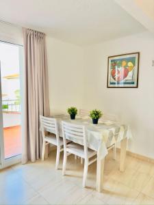 a white dining room with a table and chairs at Trill Noray 9 dúplex Estartit in L'Estartit