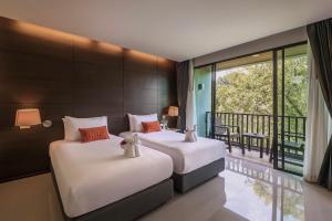 two beds in a room with a balcony at Areetara Aonang Krabi in Ao Nang Beach