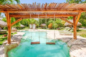 an outdoor swimming pool with a wooden pergola at Villa Morena Boutique Hotel Ecoliving in Akumal