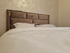 a large white bed with white sheets and pillows at Casa Denis la 50m de Castel! in Hunedoara
