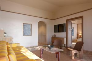 un soggiorno con divano e tavolo di Aethos Sardinia a Cannigione