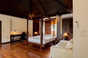 农布Luxury Thai Style Swimming Pool Villa, Private housekeeper,6 Bedrooms的一间卧室，配有一张床、一张书桌和一张沙发 更多37张照片