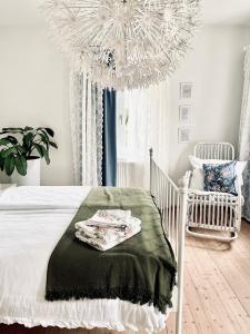 a white bedroom with a crib and a chandelier at Zauberhaftes Haus in Ortenburg in Ortenburg