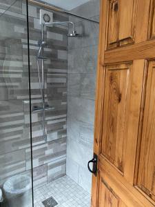 La salle de bains est pourvue d'une douche avec une porte en verre. dans l'établissement Derry City center townhouse, à Derry Londonderry