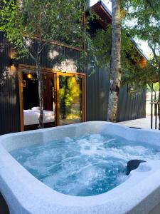 a jacuzzi tub in front of a house at Enarbol Lodge, Hot Tube en terraza in Pucón