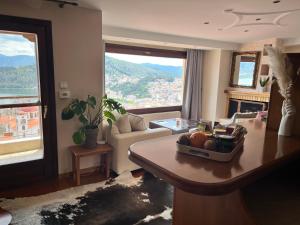 a living room with a table and a living room with a view at sunlight loft in Kastoria