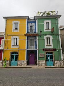 um edifício com portas e janelas coloridas numa rua em Ostello 9 em Castelnuovo Cilento