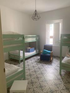 a room with two bunk beds and a chair at Ostello 9 in Castelnuovo Cilento