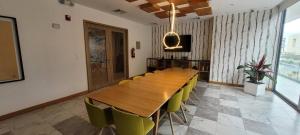 uma sala de jantar com uma mesa de madeira e cadeiras amarelas em Suite Piso #20 Con Vista Al Pichincha em Quito