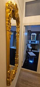 a gold mirror on the wall of a bathroom at Grand Hotel Baroc in Zalău