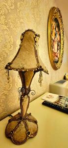 a gold lamp sitting on top of a desk at Grand Hotel Baroc in Zalău