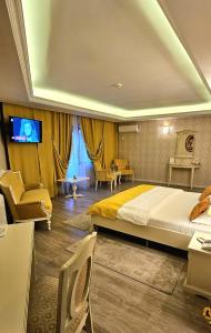 1 dormitorio con 1 cama grande y TV. en Grand Hotel Baroc en Zalău