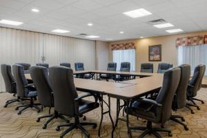 Comfort Suites Louisville Airport في لويزفيل: قاعة المؤتمرات مع طاولة وكراسي طويلة