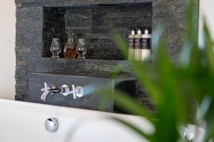 a bathroom with a sink and a fireplace at Dark Skye Cottage in Broadford
