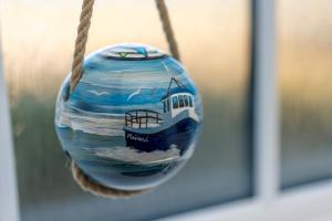 a glass ball with a picture of a boat on it at Dark Skye Cottage in Broadford