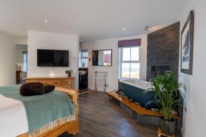 a bedroom with a bed and a bath tub at Dark Skye Cottage in Broadford