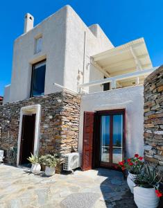 una casa con una pared de piedra y una puerta en Pasithea House en Ioulida