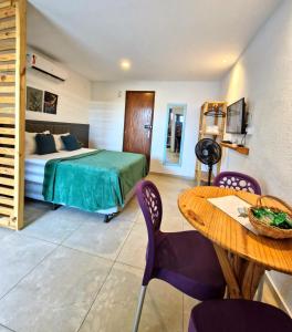 une chambre avec un lit et une table et une salle à manger dans l'établissement MSFlats Paripueira Praia Wifi Ar Cozinha e Varanda Nascente c Rede, à Paripueira