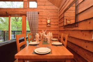 a wooden dining table in a room with a balcony at Rowan Log Cabin in Dalavich