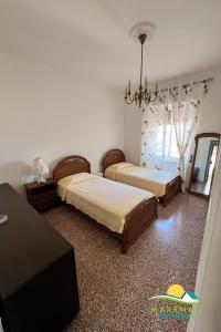 a bedroom with two beds and a chandelier at Maremma Holidays-Gardenia Apartment in Follonica