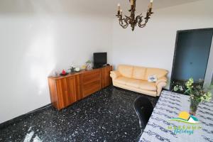 a living room with a couch and a chair at Maremma Holidays-Gardenia Apartment in Follonica