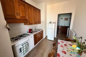 a kitchen with a stove and a sink and a refrigerator at Maremma Holidays-Gardenia Apartment in Follonica +4 photos