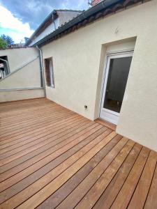 einen Balkon mit einer Holzterrasse auf einem Haus in der Unterkunft L'échappée belle d'Albi in Albi