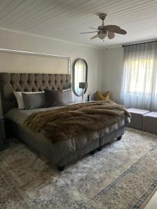a bedroom with a large bed and a couch at Florie se Huis in Paarl