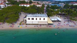 an aerial view of a beach with a white building at Beach rooms Riviera - Žuta Kuća in Makarska