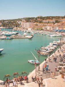 a group of people walking around a marina with boats at Hôtel Liautaud Rooftop Cassis in Cassis
