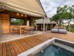 Bushveld Bivouac Private Camp في Mica: سطح خشبي مع طاولة وأريكة